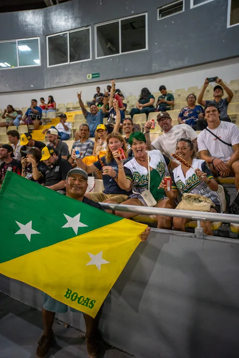 Fans in the stands holding up the green and yellow Bocas flag