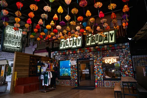 The Too Much Tours shop on Avenida E Norte, with a tiled front, a Filthy Friday sign and colorful lanterns