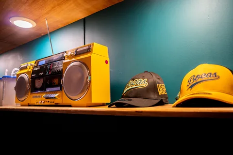 A yellow boombox and Bocas caps on a shelf in the shop