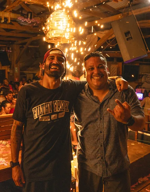 Two friends smiling under sparkler lights at a party