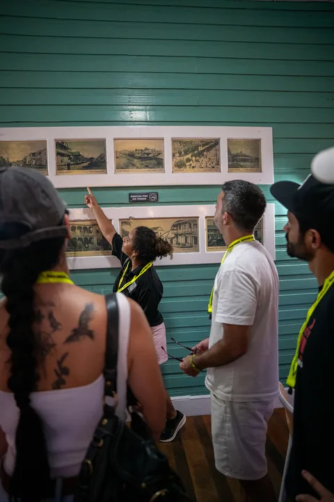 Tour guests looking at framed historic photos of Bocas on a wall