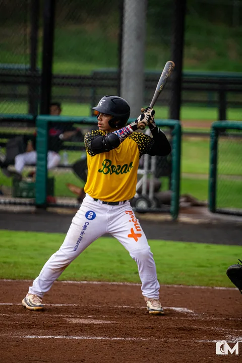 A Bocas batter in a yellow jersey waiting for the pitch